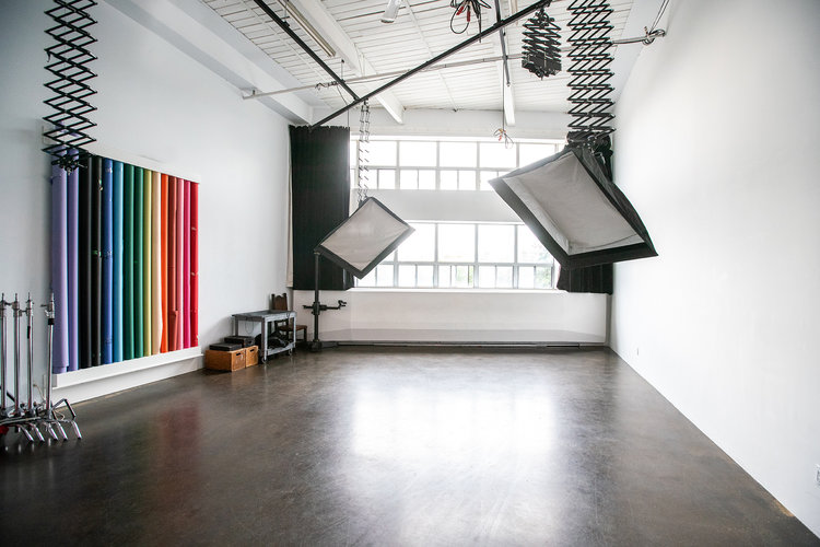 photo studio with wood floors, large windows and studio lights