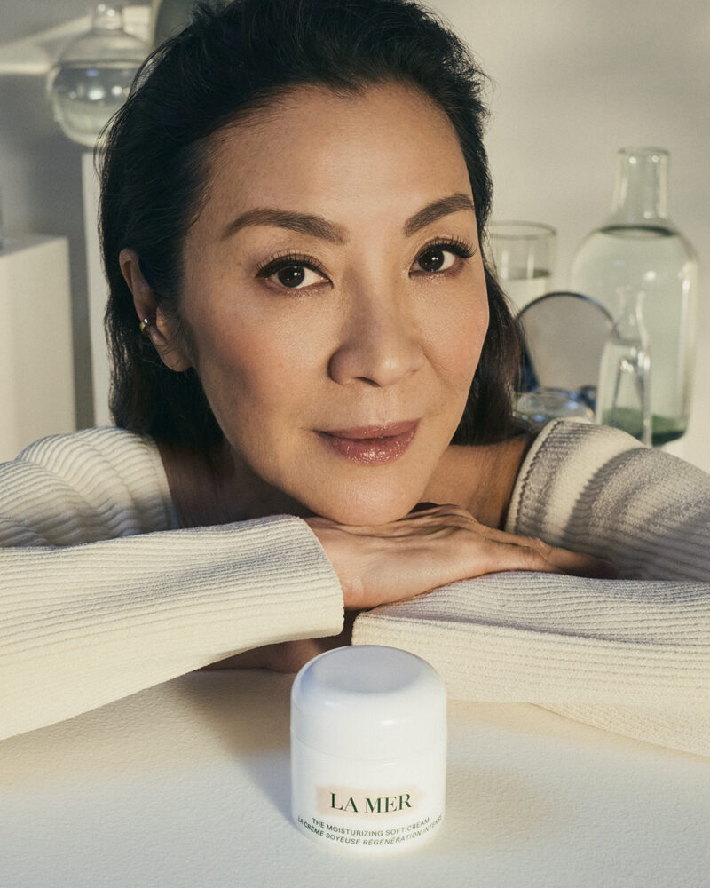 Michelle Yeoh posing with La Mer Moisturizer