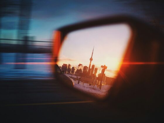 The Toronto skyline reflected in a car's side mirror.
