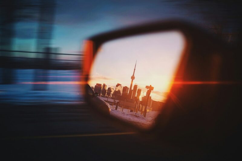 The Toronto skyline reflected in a car's side mirror.