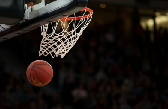 Basketball going through the hoop at an NBA game.