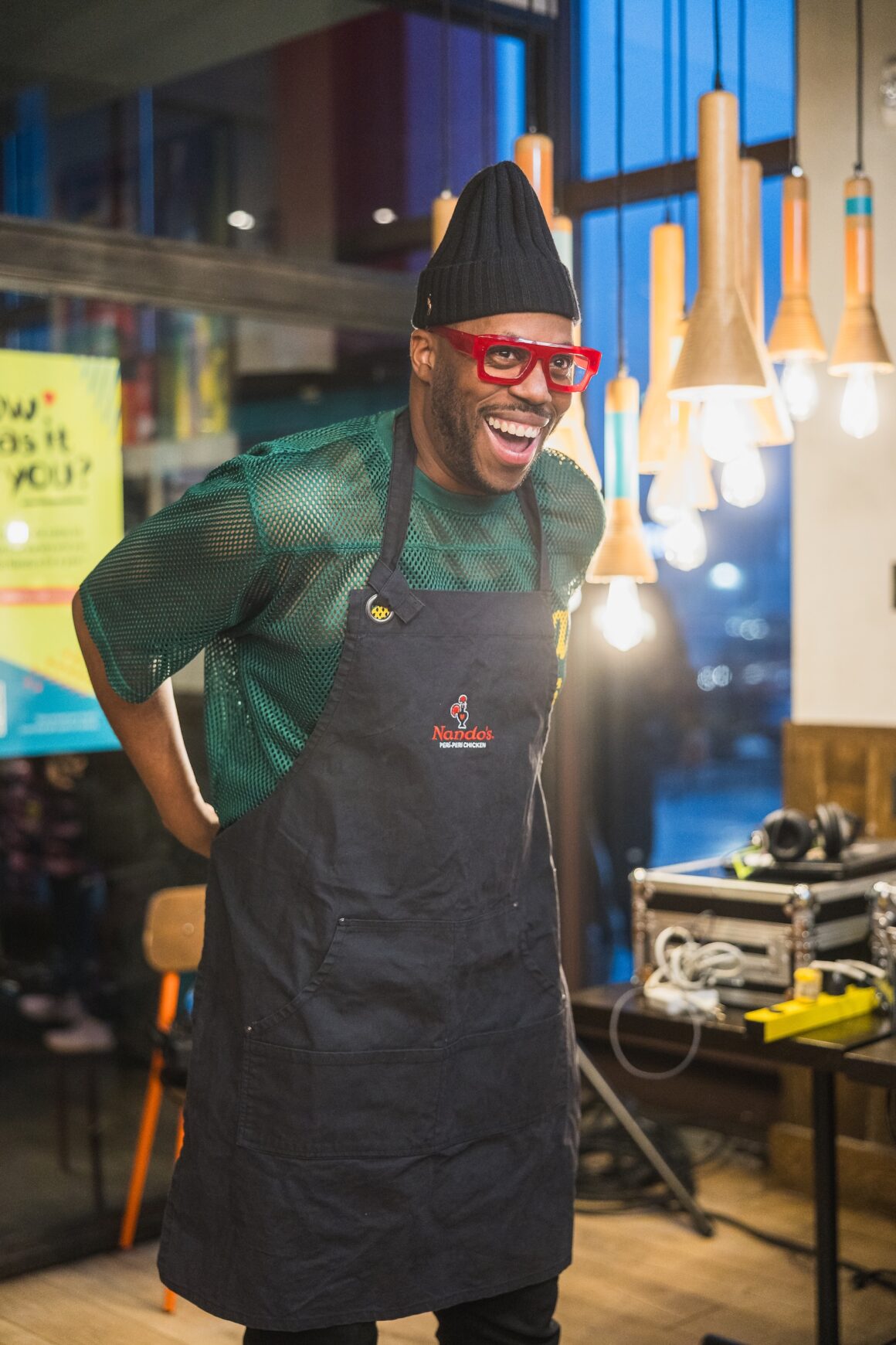 Kardinal Offishall putting on his apron. (Photo: Tom Wang for Nando's)
