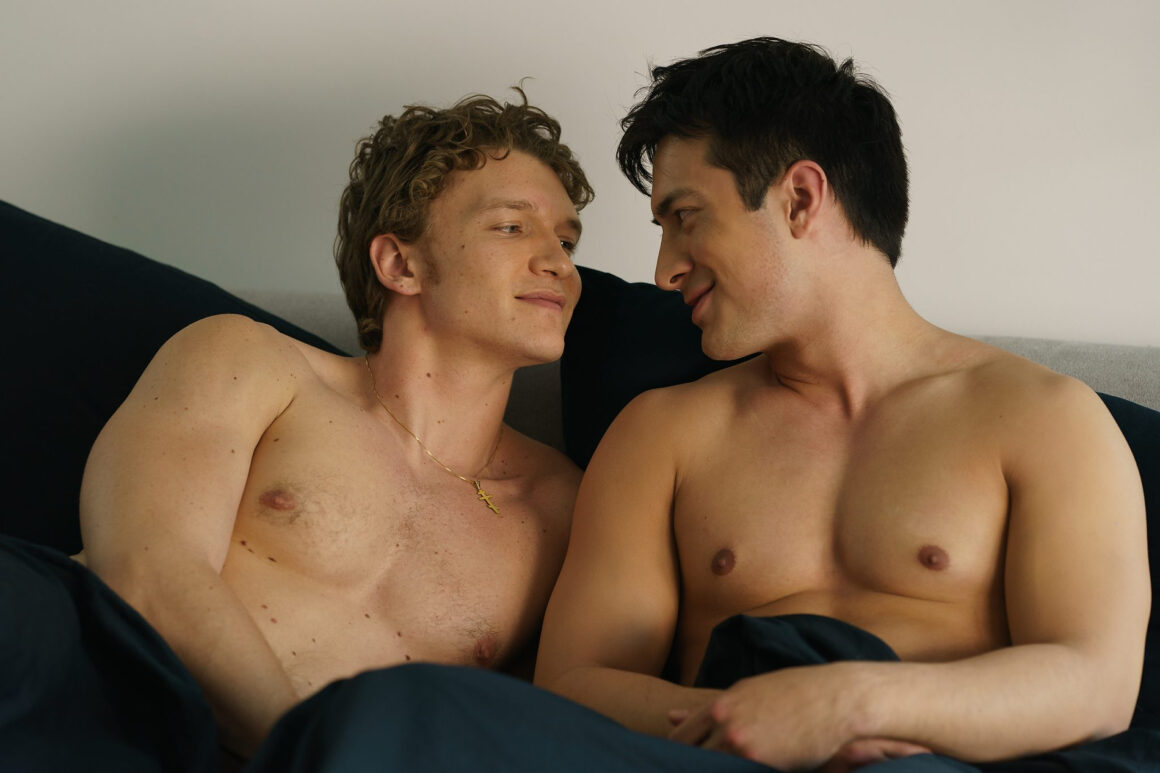 Heated Rivalry episode 4 scene where Shane Hollander and Ilya Rozanov lie together in bed, sharing an intimate, emotional moment