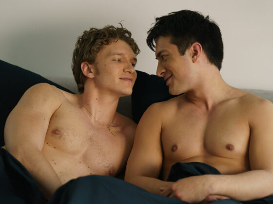 Heated Rivalry episode 4 scene where Shane Hollander and Ilya Rozanov lie together in bed, sharing an intimate, emotional moment